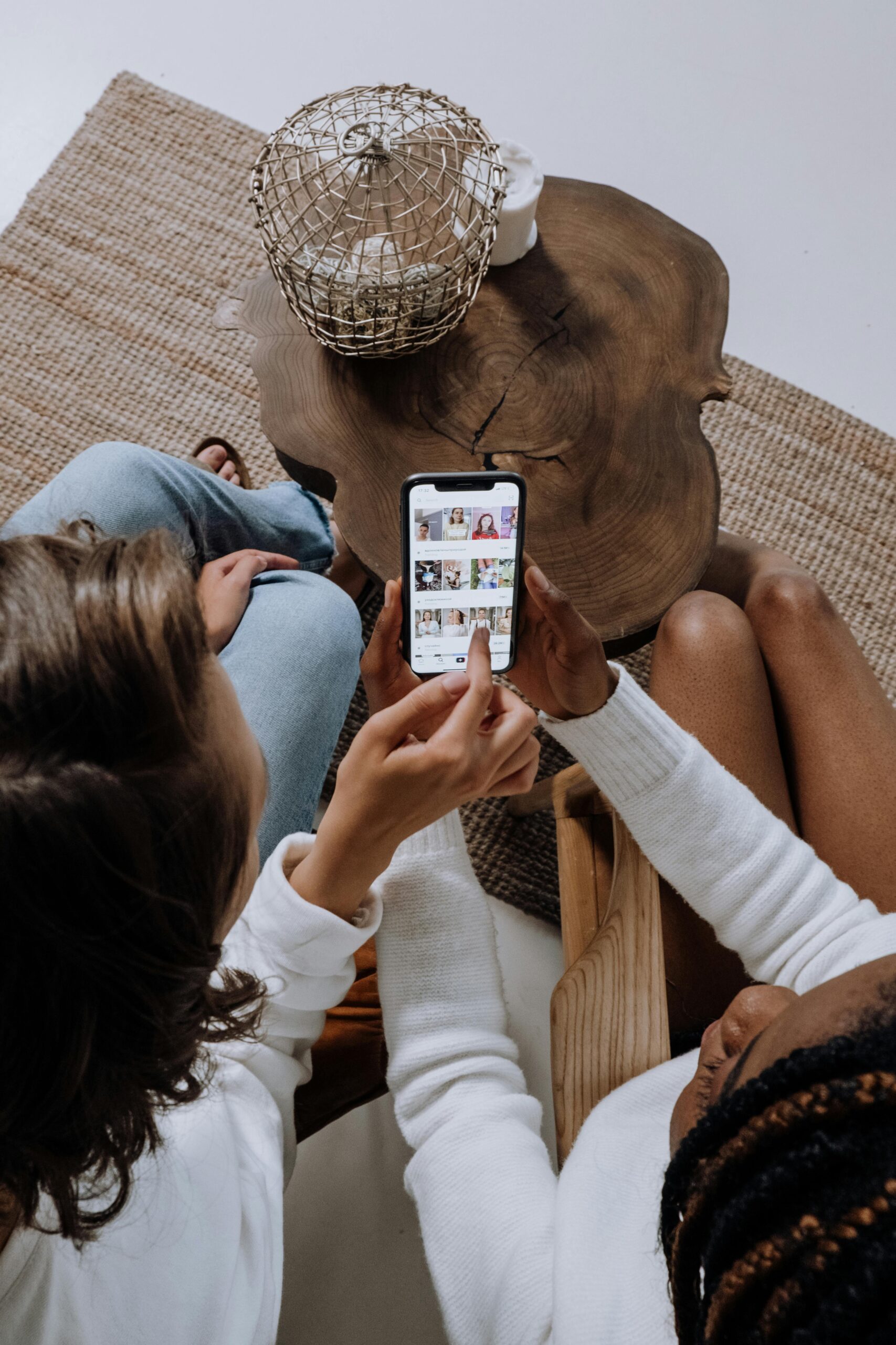 Zwei Frauen schauen sich einen Social Media Feed auf dem Smartphone an